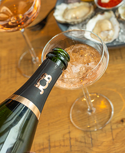 Close up of a bottle of champagne being poured into a glass.